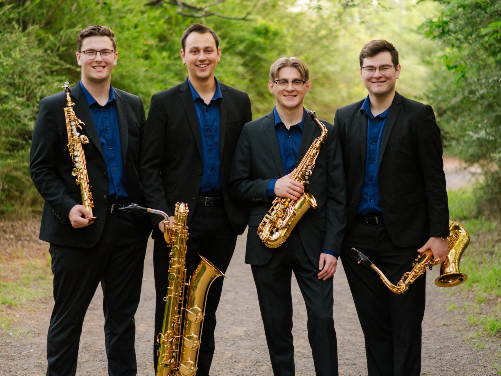 Novus Quartet standing with saxophones outdoors.
